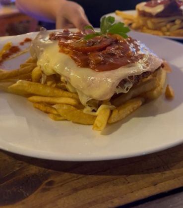 Milanesa napolitana con muzzarella y salsa sobre papas fritas